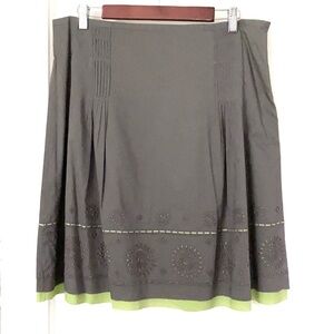 Gray cotton skirt with bright green lining revealed through eyelet details